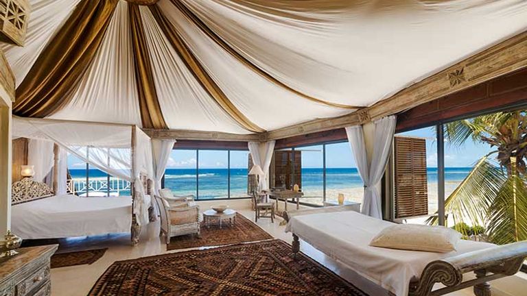 The master bedroom on the top floor of the Cliff Villa includes handcrafted furniture and stunning panoramic views. // © 2016 Alfajiri Villas